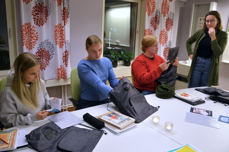 Tilde Svahn, Elvira Ersson och Einar Wanhatalo Björnström, gymnasieelever i Övertorneå, får varsitt exemplar av språkpaketet Kielisäkki av Evelina Estola, språkfrämjare vid Språkcentrum meänkieli. Foto: Göran Lahti. Tilde Svahn, Elvira Ersson och Einar Wanhatalo Björnström, gymnasieelever i Övertorneå, får varsitt exemplar av språkpaketet Kielisäkki av Evelina Estola, språkfrämjare vid Språkcentrum meänkieli. Foto: Göran Lahti.
